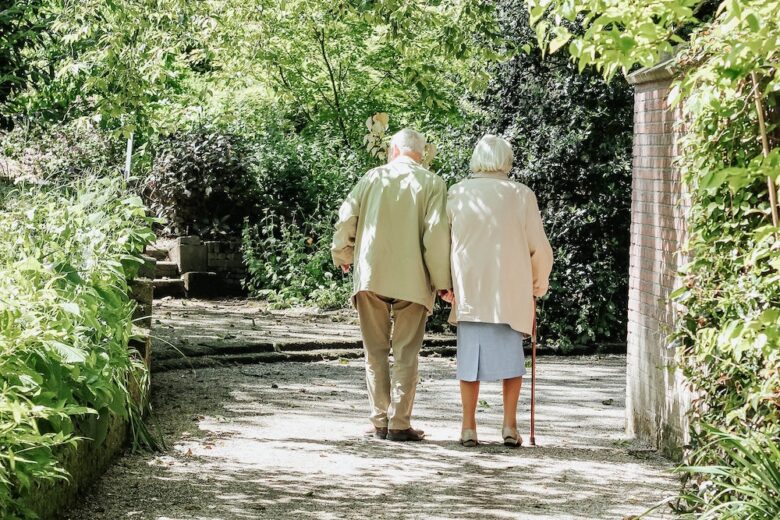 Elderly couple walking together in a garden